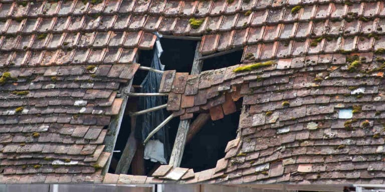 a home with storm damage on roof to determine a roof repair vs replacement