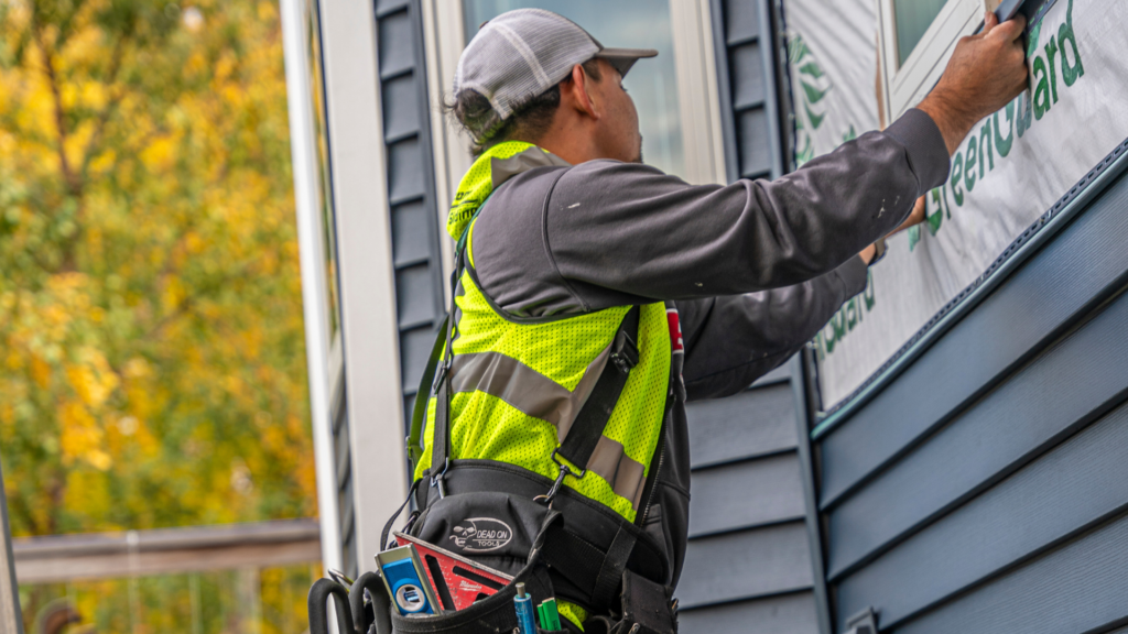 a photo of a man installing sidings