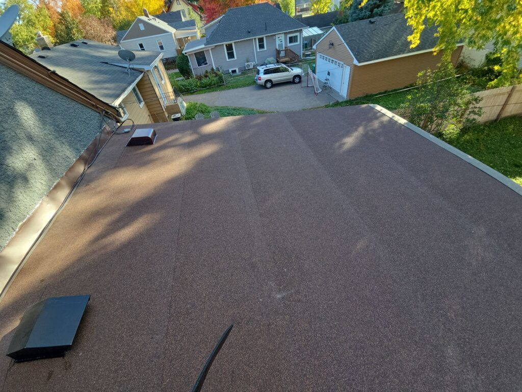 Newly installed low-slope roof section on an older Twin Cities home