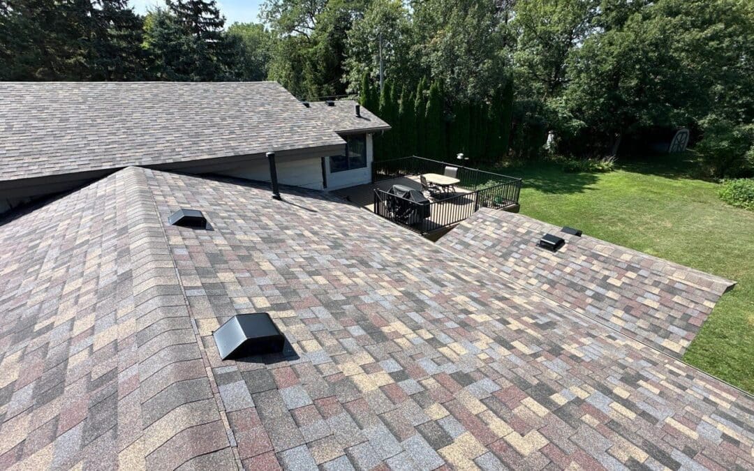 Completed tear-off and new shingle roof on a split-level home with deck and backyard