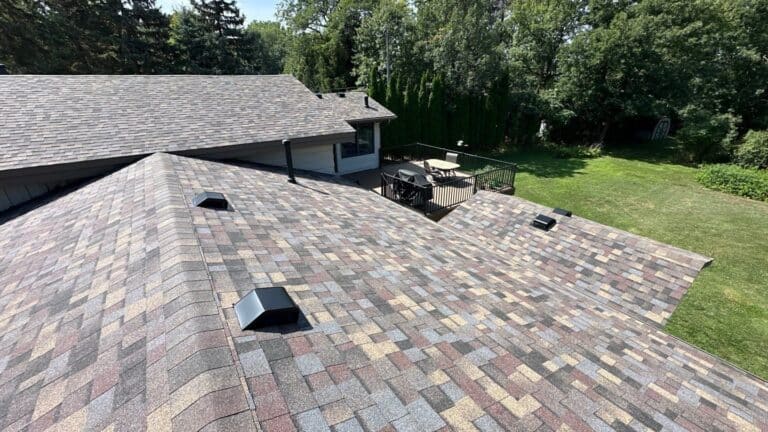 Completed tear-off and new shingle roof on a split-level home with deck and backyard